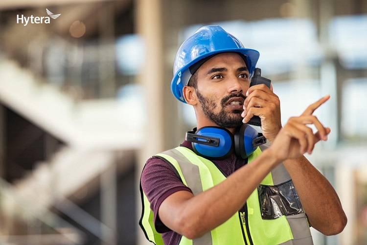 Construction supervisor using walkie talkie