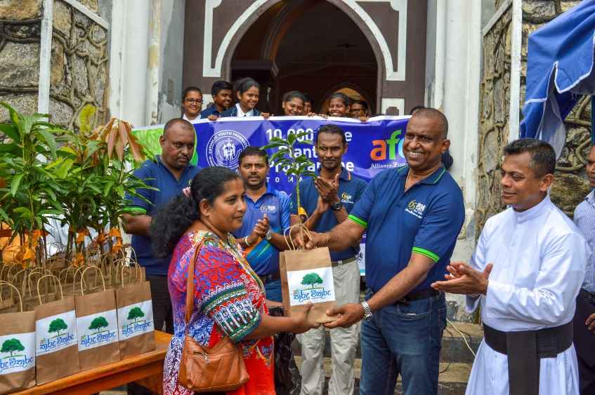 Pic2-Mr-Michael-Benedict-Director-–-Recoveries-AFC-along-with-Rev.-Fr.-Damien-Arsakularatne-handing-over-plants-to-the-family-community-LBN.jpg