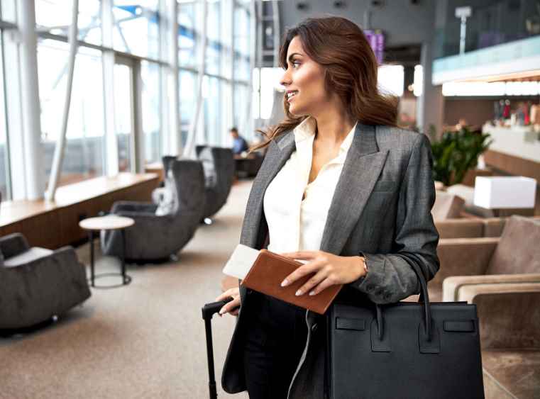 Smiling,Young,Woman,With,Ticket,And,Bag,Standing,In,Departure