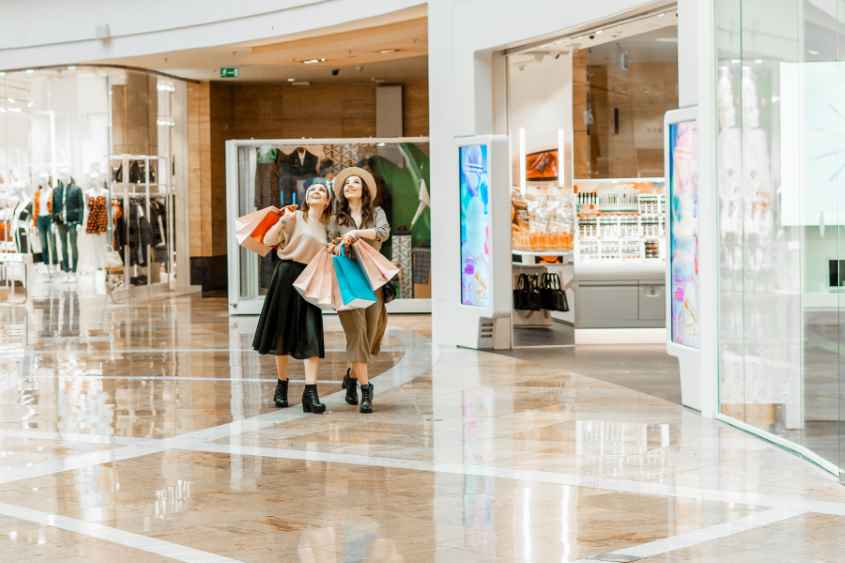 Shopping,And,Entertainment,,Mall,Inside.,Two,Beautiful,Girls,With,Paper